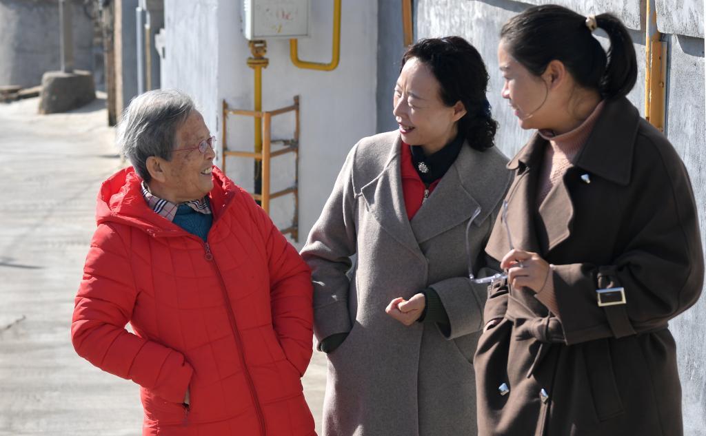 在陜西省榆林市佳縣，路生梅與志愿服務(wù)機(jī)構(gòu)的工作人員聊天（2022年11月15日攝）。新華社記者 鄒競一 攝